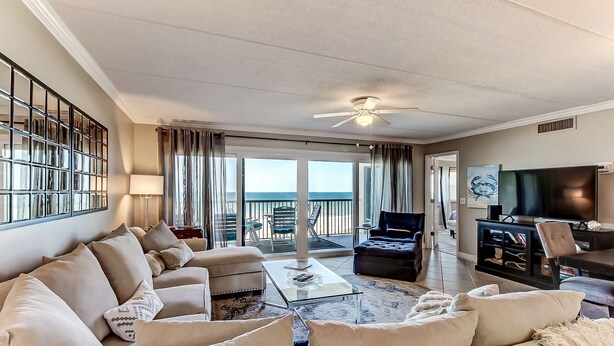 A spacious living room with a large sofa set, a coffee table, and a TV area. - Beachfront Family Condo w/ Pool, Fishing, and Pier Access Amelia by the Sea (Fernandina Beach)