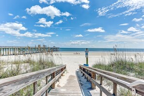 A wooden boardwalk leading to a beach with a clear sky and distant shoreline. - Oceanfront 2BR w/ Stunning Views Amelia by the Sea (Fernandina Beach)