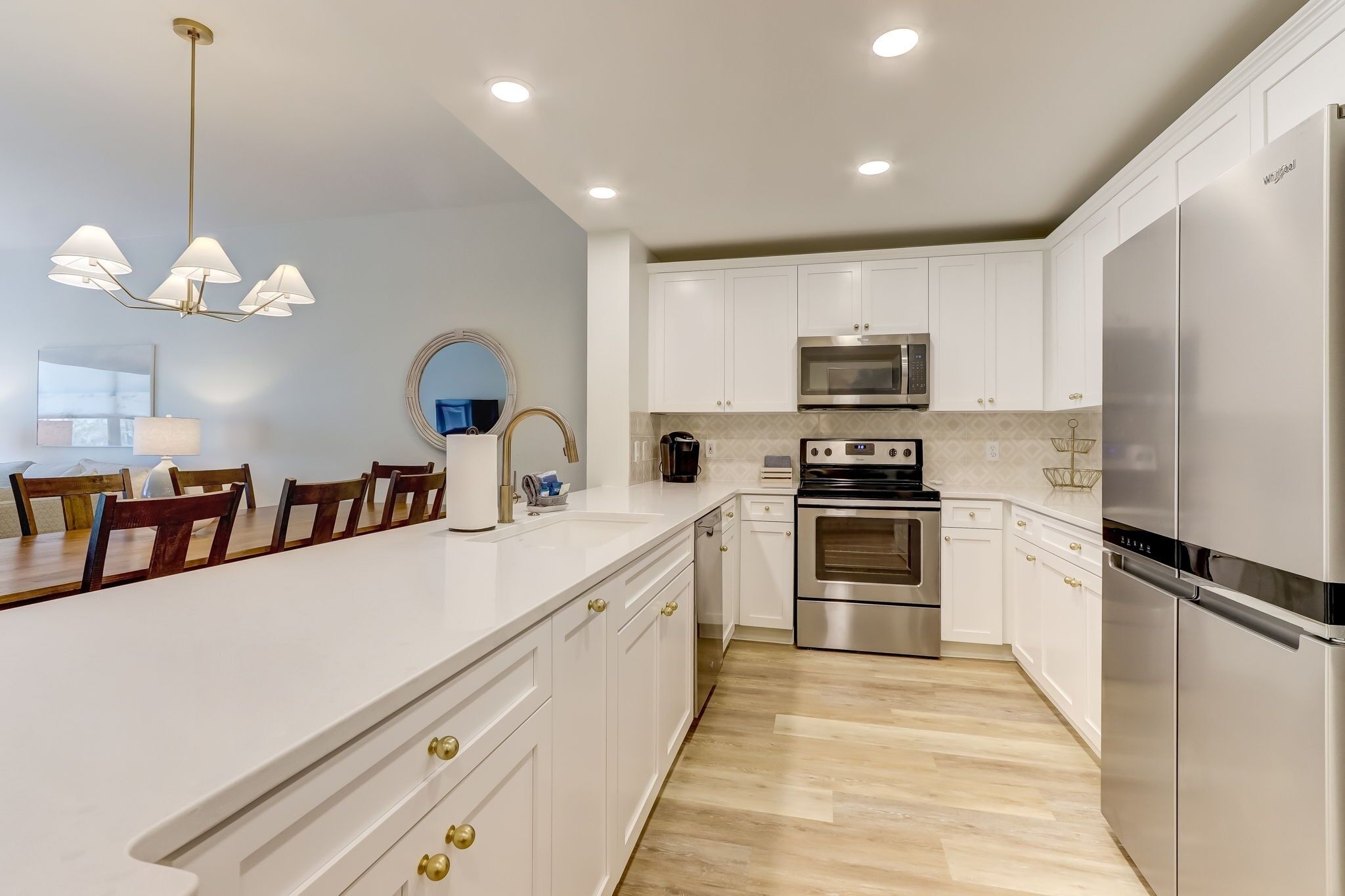 A modern kitchen with white cabinets, stainless steel appliances, and a central island with seating.
