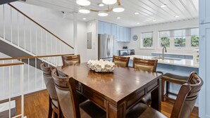 A modern kitchen with white cabinets, stainless steel appliances, and a large island. - Charming Family Retreat w/ Ocean View Sandpiper Loop - 95076 (Fernandina Beach)