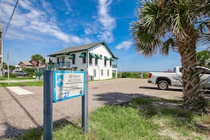 A beach access sign for the City of Fernandina Beach, Florida, with a view of a white building with green accents and a palm tree in the foreground. - Newly Renovated 2BR by the Beach Amelia Island (Fernandina Beach)