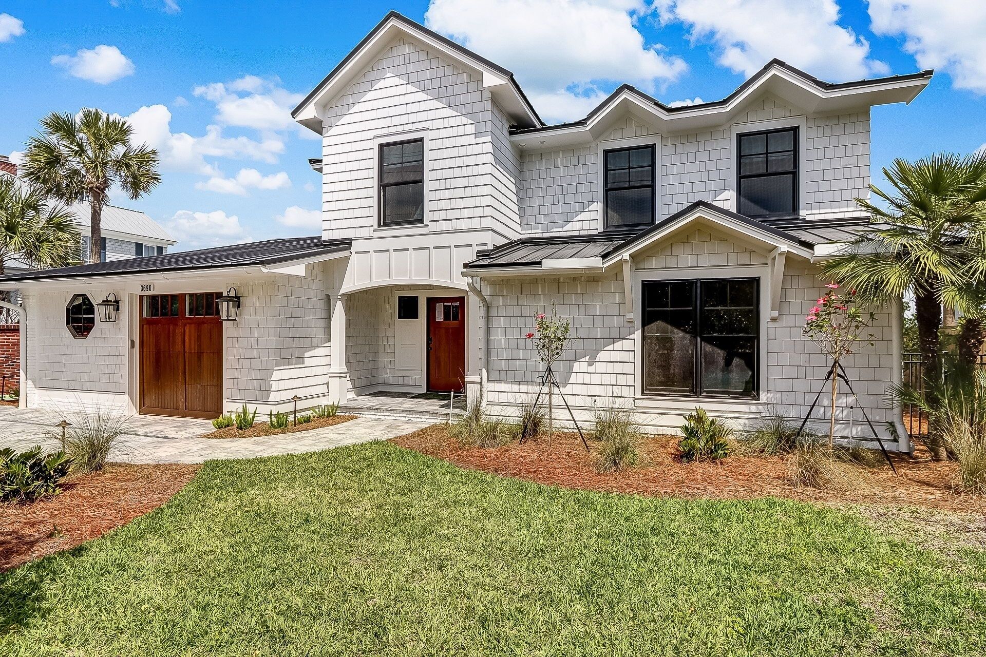 A two-story house with a white exterior, a front porch, and a well-maintained lawn.