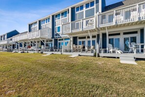 A row of beachfront cabins with balconies, outdoor seating, and a grassy lawn. - Sunlit Paradise in Amelia Island 3BR Beachfront Home (Fernandina Beach)