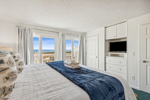 A hotel room with a bed, a TV, and a view of the beach. - Sunlit Paradise in Amelia Island 3BR Beachfront Home (Fernandina Beach)