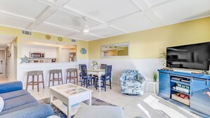 Una sala de estar moderna con sofá, mesa de centro y mueble para televisión.