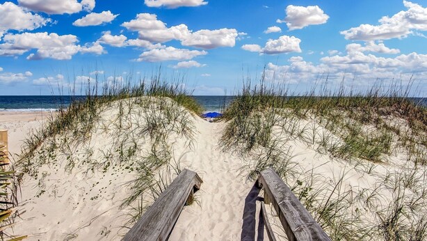 A sandy beach path leading to the ocean with a wooden boardwalk and a blue umbrella in the distance. - Vintage Ocean View Paradise - 1BR - Beachfront (Fernandina Beach)