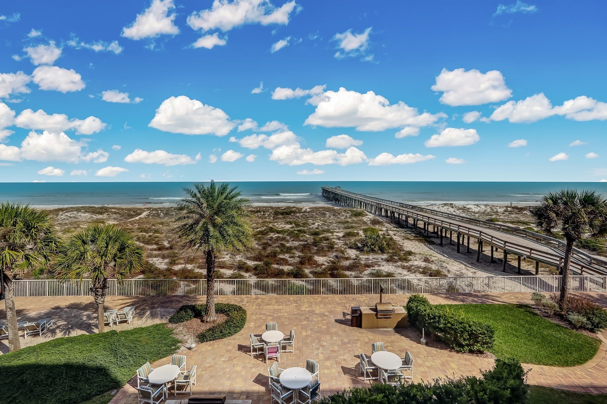 A beachside patio with outdoor seating and a view of the ocean.
