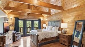 Un dormitorio de cabaña de madera con cama, cómoda y un espejo grande.