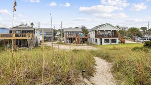 A beachfront property with multiple houses, a sandy path, and a clear sky. - Spacious Beachfront Duplex - Top Floor - Dog Friendly 124 S Fletcher (Fernandina Beach)