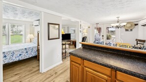 A modern kitchen with a granite countertop, wooden cabinets, and a 'Welcome to the Beach' sign. - Spacious Beachfront Duplex - Dog Friendly - Downstairs 124 S Fletcher (Fernandina Beach)