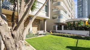 Un hotel moderno con fachada de piedra, césped cuidado y un letrero llamativo que dice "Grand Pavilion".