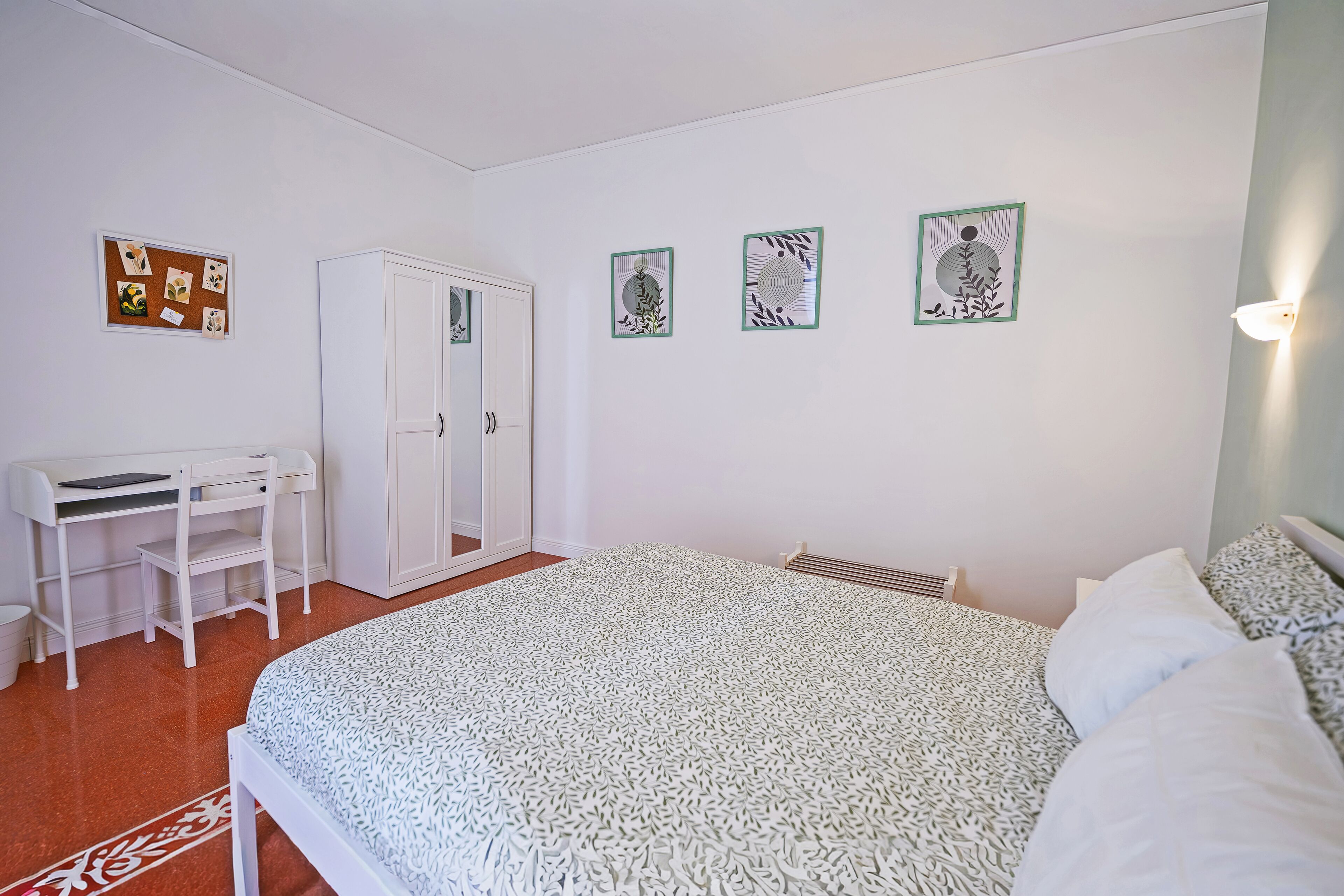 Una camera da letto con un letto, una scrivania e un armadio.