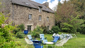 A stone building with a garden patio featuring outdoor furniture. - Spacious Family Home with Private Terrace, Garden & Wi-Fi in Saint Lormel (Saint Lormel)