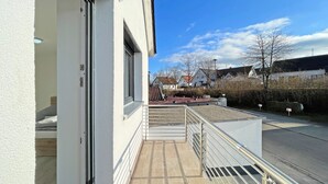A building exterior with a balcony, a door, and a clear sky. - Apartment '5' with Private Terrace, Shared Garden and Wi-Fi (Ichenhausen)
