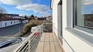 A balcony with a metal railing, a white building, and a clear sky. - Apartment '5' with Private Terrace, Shared Garden and Wi-Fi (Ichenhausen)