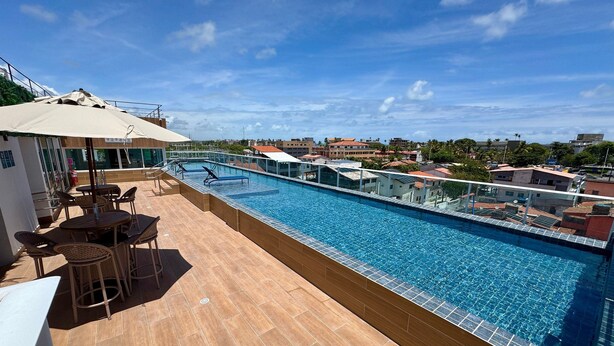 A rooftop pool with a view of the city, outdoor seating, and a covered area. - Waikiki Garden (Ipojuca)