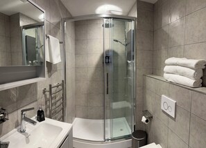 Tina con regadera, toallas, jabón, shampoo 