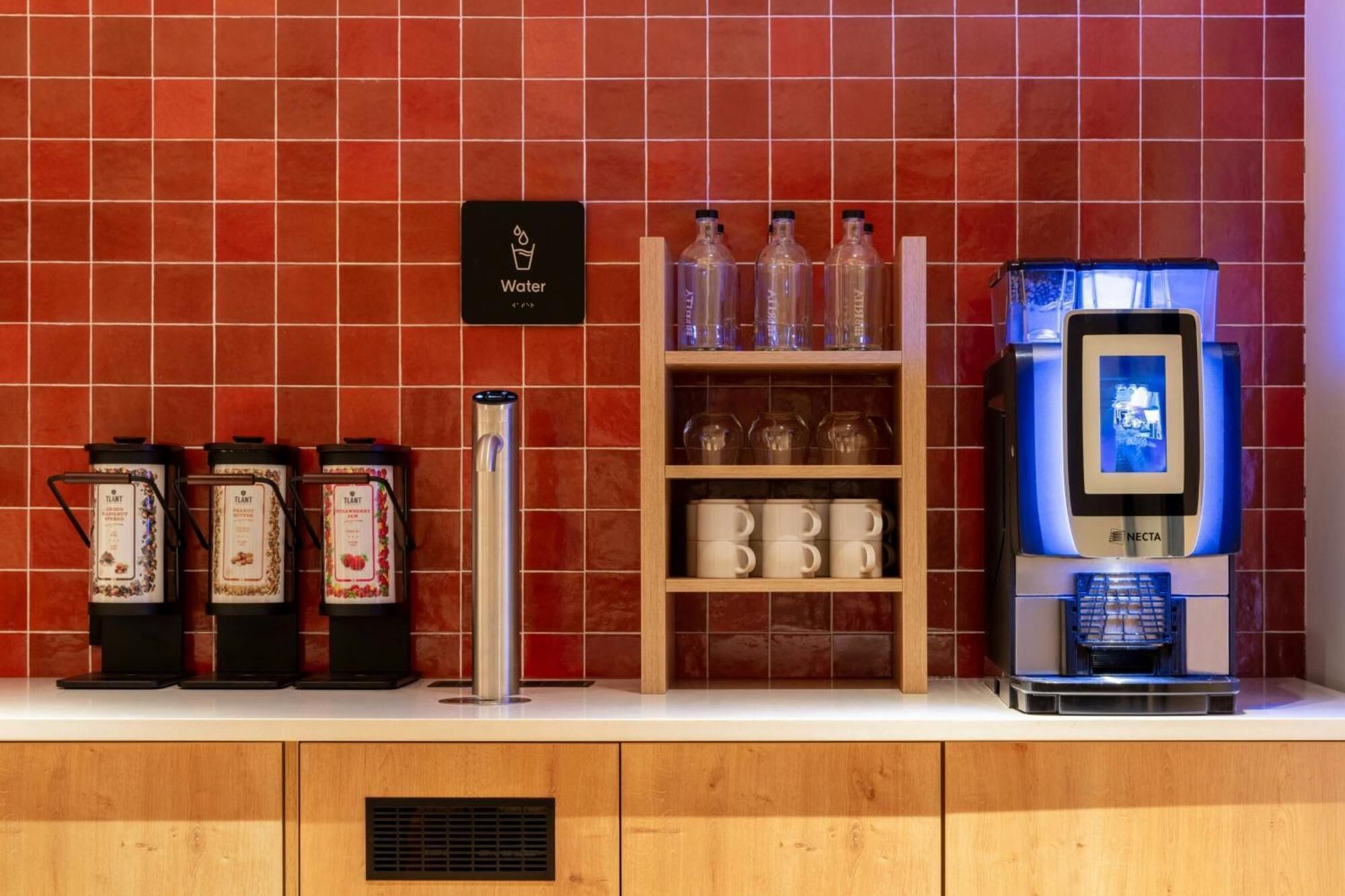 A coffee station with a water dispenser, a coffee machine, and various coffee containers.