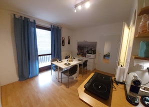 A compact kitchen with a dining table, a microwave, and a coffee machine. - Apartment 'Golden Base' with Mountain View, Wi-Fi, and Air Conditioning (Villach)