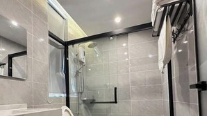 Une salle de bain moderne avec une douche à parois de verre, des toilettes et un meuble-lavabo avec un miroir.