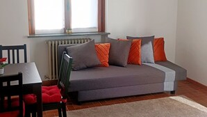 Ein kompakter Wohnbereich mit einer Couch, einem Esstisch und Stühlen.