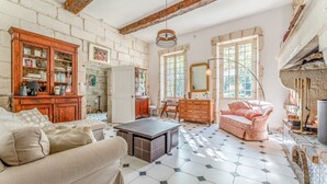 Uma sala de estar ampla, com um sofá, uma mesa de centro e uma lareira.