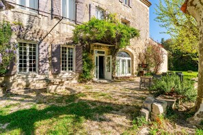 A stone building with a garden entrance, a small door, and a window with shutters. - “Steven” Room with Shared Pool, Shared Garden, and Wi-Fi (Saint-Rémy-de-Provence)