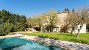 A swimming pool, a house with a garden, and a clear blue sky. - "Sacha" Room at Mas de Kitty, Shared Pool (Saint-Rémy-de-Provence)