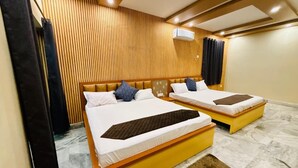 Ein Hotelzimmer mit zwei Betten, Holzvertäfelung an den Wänden, einem Marmorboden und einer Klimaanlage.