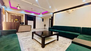 Ein modernes Wohnzimmer mit einem grünen Sofa, einem Marmortisch und einer Rezeption.