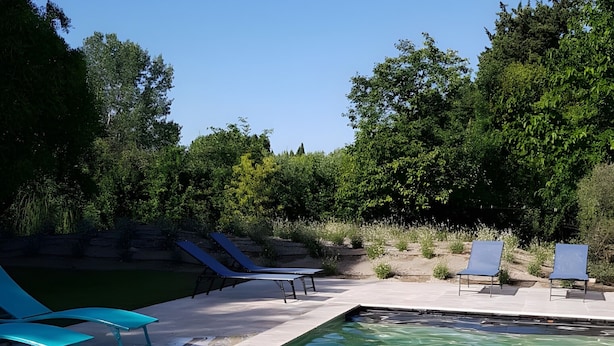 A clear swimming pool with blue lounge chairs and a stone deck. - Spacious Studio Le Mas de Kitty, Shared Garden and Pool (Saint-Rémy-de-Provence)