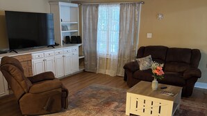 A living room with a brown leather recliner, a brown sofa, a wooden coffee table, and a TV on a stand. - Spacious 3BR/2BA Downtown Eufaula Home Near Lake & Hospital (Eufaula)