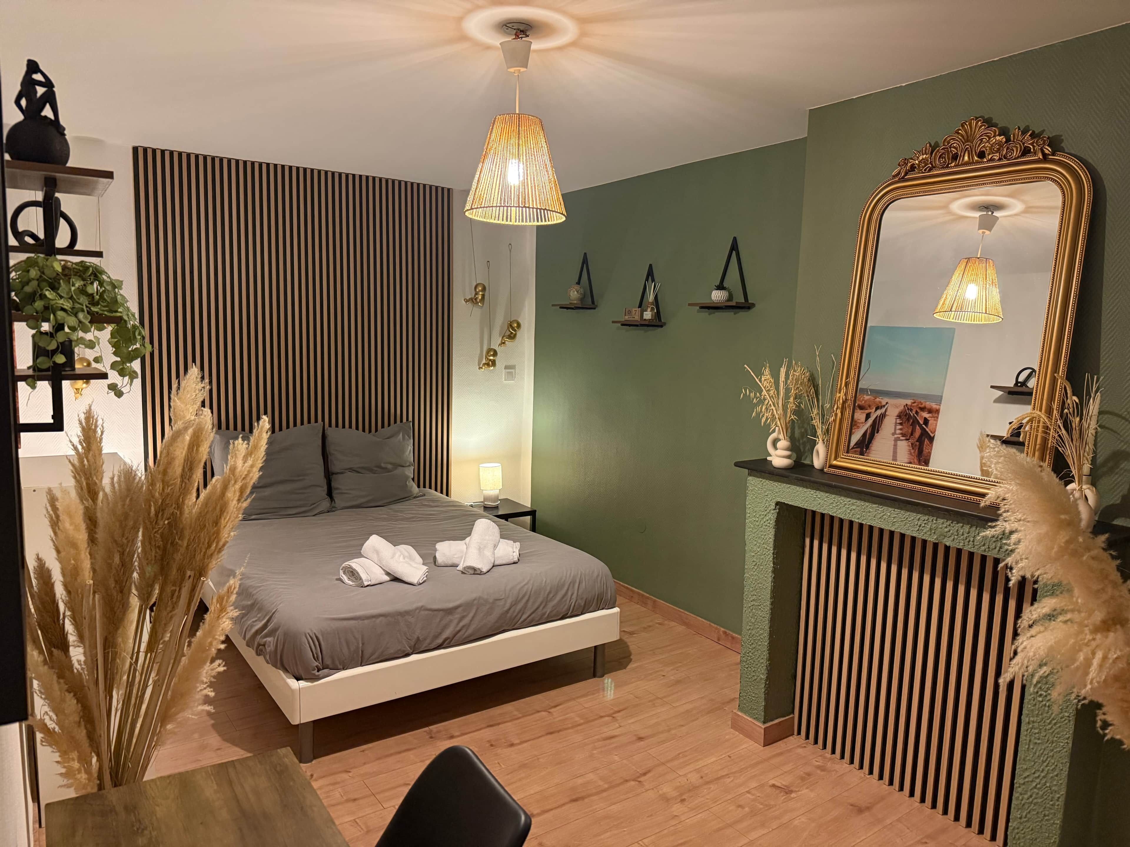 Une chambre à coucher moderne avec un lit, des tables de chevet, un miroir et une cheminée.