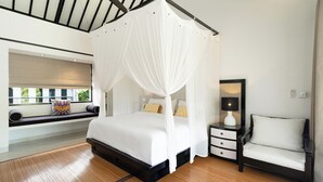 A bedroom with a four-poster bed, a bedside table with a lamp, a chair, and a window with a view of greenery. - Bali - Laidback Haven in Ubud with River & Jungle View (Kecamatan Ubud)