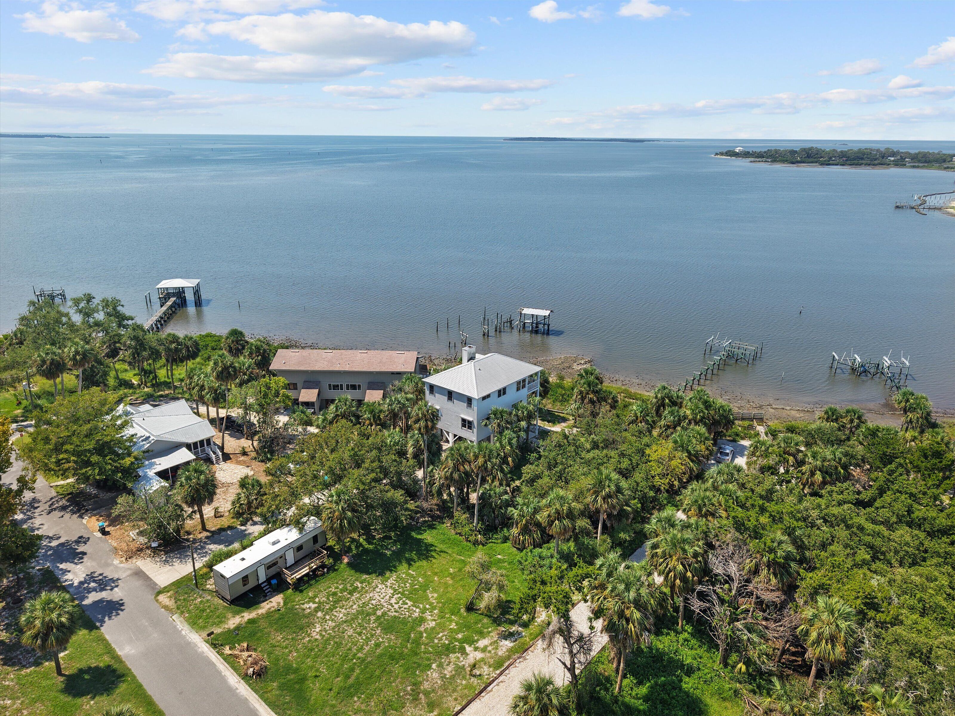 A lakeside property with a house, dock, and RV.