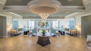 A spacious lobby with a central round table, seating area with sofas, and a chandelier. - Beachfront 4BR Silver Beach Towers West 306 (Destin)