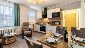 Een moderne keuken met een eethoek, een bank en een tafel gedekt voor twee personen.