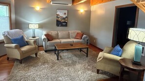 A cozy living room with a beige sofa, two armchairs, a coffee table, and a rug. There is a painting on the wall and a lamp on a side table. - Cozy 2+ bedroom house in beautiful Springfield (Springfield)