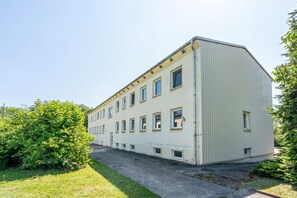 Ein mehrstöckiges Gebäude mit flachem Dach und einer Reihe von Fenstern in jeder Etage.