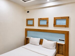 Un dormitorio con una cama, cabecera de madera y tres marcos cuadrados en la pared.