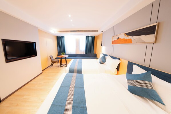 Una camera d'albergo con un letto, una televisione, una scrivania e una sedia.
