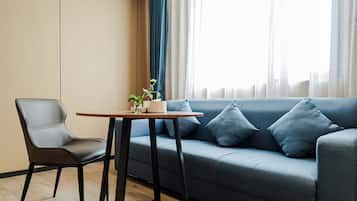 A modern living room with a grey sofa, a wooden table, and a chair.