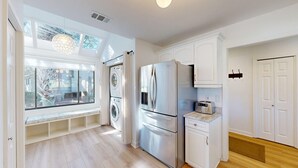 Una cucina moderna con elettrodomestici in acciaio inossidabile, forno integrato e finestra vista giardino.