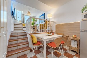 A kitchen with a dining area, a staircase, and a view of the outside. - Arche Noa Apartment with sea view (Los Gigantes)