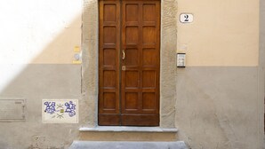 A double wooden door with a number '2' above it, set in a beige wall with a small window below. - Tornabuoni Cozy Apartment (Firenze)