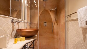 A modern bathroom with a large copper sink, a glass shower enclosure, and a towel rack. - Tornabuoni Cozy Apartment (Firenze)