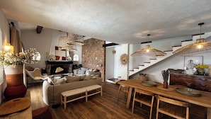 A cozy living room with a stone wall, wooden furniture, and a fireplace. - Villa with sea and Esterel views: 5 bedrooms, swimming pool, air conditioning. (Saint-Raphaël)