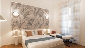 A hotel room with two beds, a large wall tapestry, and a window with sheer curtains. - ReRent Rooms - 81 MANZONI GUESTHOUSE (Rome)