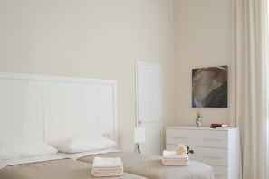 A hotel room with a bed, a nightstand, a dresser, and a painting on the wall. - Tornabuoni Classic Apartment  (Firenze)