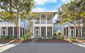A two-story house with a balcony, large windows, and a front porch. - Upscale Watercolor Home + Golf Cart, Bikes & Pools (Santa Rosa Beach)